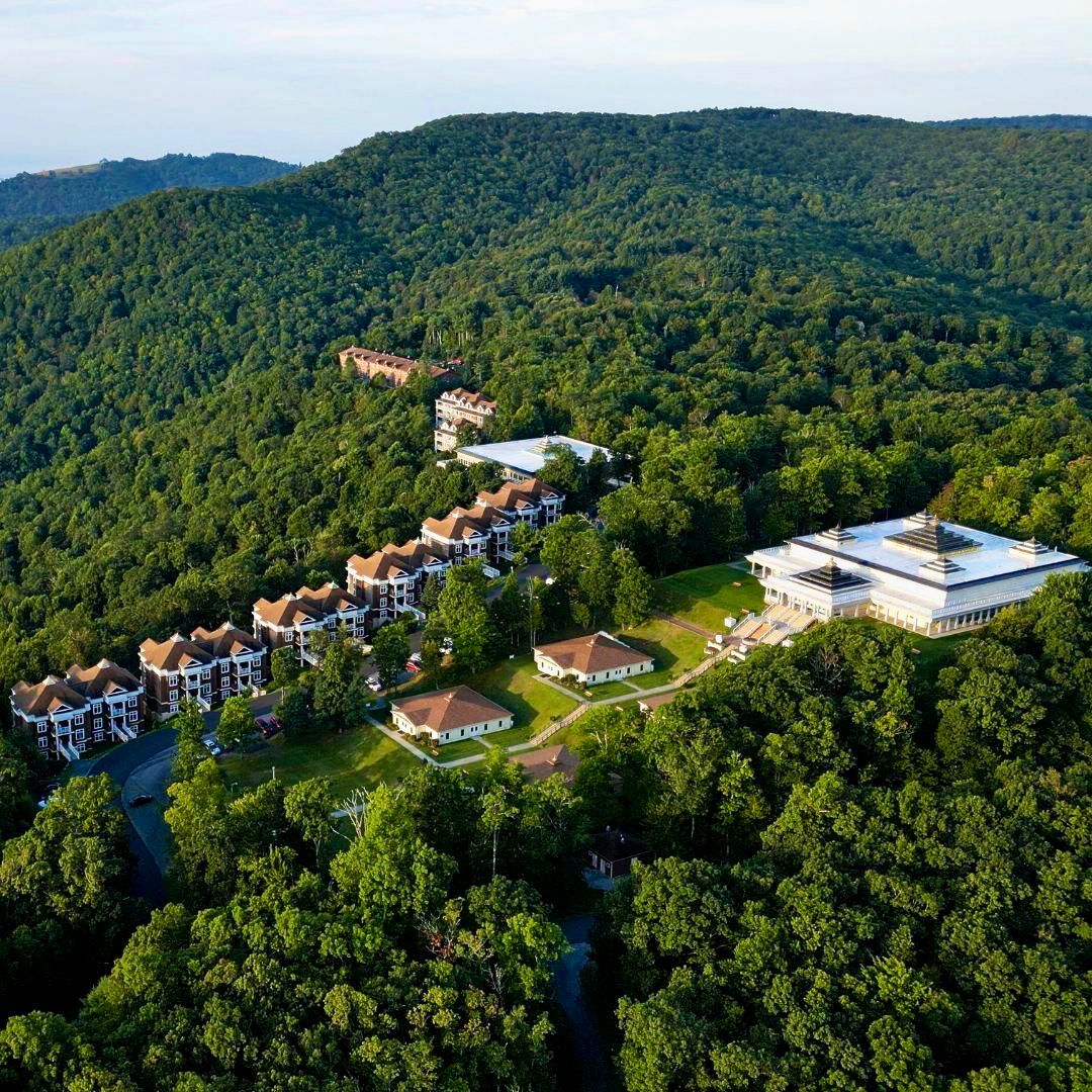 An aerial view of a hospitality property nestled in a forested mountainside